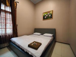 a small bedroom with a bed with a tray on it at De Hanami Homestay Setrayasa in Cirebon
