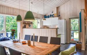 GræstedにあるBeautiful Home In Grsted With 4 Bedrooms, Sauna And Wifiのキッチン(木製テーブル、椅子付)