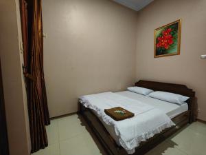 a bedroom with a bed with a picture on the wall at De Hanami Homestay Setrayasa in Cirebon
