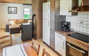 eine Küche mit einem weißen Kühlschrank und einem Tisch mit Stühlen in der Unterkunft Ferienhaus Am Trieberweg S in Falkenstein