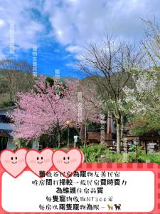 un segno con due cuori davanti a un albero di 薔薇谷 民宿字108號 a Fuxing