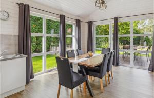 een eetkamer met een tafel, stoelen en ramen bij Nice Home In Krems Ii-warderbrck With House A Panoramic View in Göls