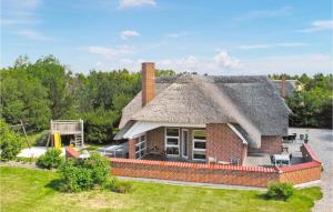 a house with a thatched roof with a yard at Gorgeous Home In Blvand With Kitchen in Blåvand