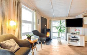 a living room with a couch and chairs and a television at Gorgeous Home In Blvand With Kitchen in Blåvand
