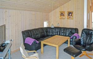 uma sala de estar com um sofá de couro preto e uma mesa em Amazing Home In lbk With Wifi em Ålbæk