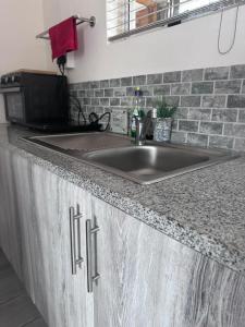 a kitchen counter with a sink and a microwave at 14 on Braemar in Durban