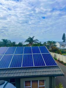 un grupo de paneles solares en el techo de una casa en 14 on Braemar en Durban