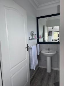 een witte badkamer met een wastafel en een spiegel bij 14 on Braemar in Durban