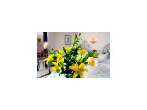 a vase of yellow flowers in a room at Seibel's Park Hotel in Munich