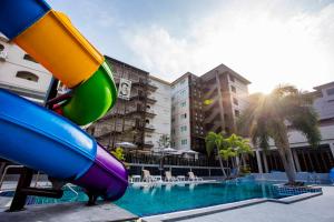 a pool with a slide in front of a building at Sabai Inn in Pattaya