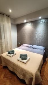 a bedroom with a large bed with towels on it at DOMUS VACANZE ROMANE in Rome