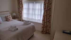 1 dormitorio con toallas en una cama con ventana en Shieling Cottage at Lovelady Shield, en Alston