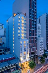 a tall building with lights on in a city at Navy Hotel Nha Trang in Nha Trang
