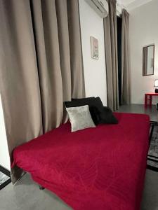 łóżko z czerwonym kocem w pokoju w obiekcie Immense Studio EmpireDamansara/WiFi/Netflix w mieście Petaling Jaya