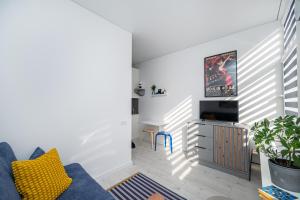 een woonkamer met een blauwe bank en een tv bij Studios K1A in Vilnius