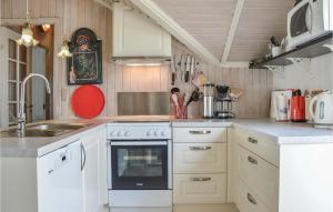 a kitchen with white cabinets and a stove top oven at Holiday Home Ørnevej Sjællands Odde Denm in Yderby