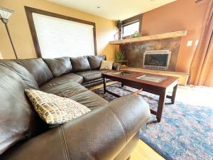 a living room with a leather couch and a coffee table at Hill City Haven Downtown Main Street in Hill City