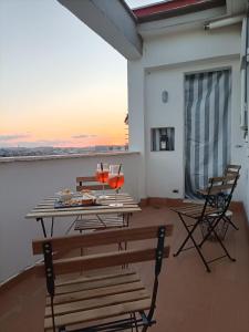 a table and chairs on a balcony with the sunset at DOMUS VACANZE ROMANE in Rome