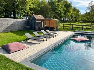 a group of chairs sitting next to a swimming pool at Gite Le Clos Sainton in Saint-Hilaire-Saint-Mesmin