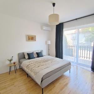 una camera da letto con un letto e una grande finestra di GuestHouse Maison Comfort a Kula