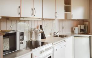 a kitchen with white cabinets and a sink at Beautiful Home In Ringkbing With Wifi in Klegod