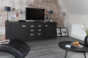 een woonkamer met een televisie op een dressoir bij Luxe en ruim appartement in Rijksmonument in Vianen
