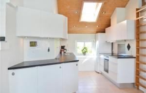 een keuken met witte kasten en een houten plafond bij Nice Home In Thisted With Indoor Swimming Pool in Klitmøller