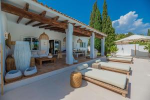 an outdoor patio with lounge chairs and an umbrella at VACATION MARBELLA I Villa Ballesteros, Near Golf Courses, Private Pool and Gigantic Garden in Estepona