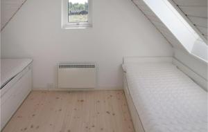 Cette chambre mansardée comprend 2 lits et une fenêtre. dans l'établissement Lovely Home In Strandby With Wifi, à Strandby