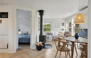a living room with a bedroom and a living room with a table at 2 Bedroom Awesome Home In Kerteminde in Kerteminde
