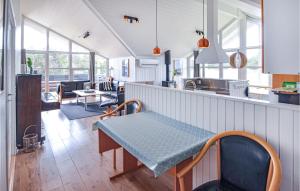a kitchen and living room with a table and chairs at Nice Home In Thisted With 5 Bedrooms, Sauna And Wifi in Klitmøller