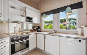 a kitchen with white cabinets and a window at Cassiopeia in Sjølund