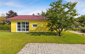 a yellow house with a tree in front of it at Lovely Home In Krems Iiwarderbrück in Göls