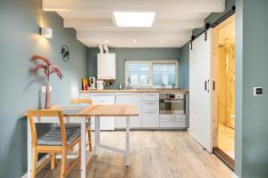 a kitchen with a wooden table and chairs at Studio Luxe 31 Zandvoort met gratis parkeerplaats in Zandvoort