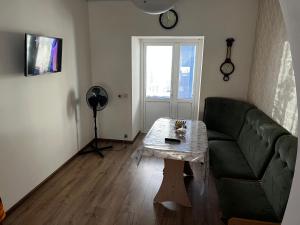 a living room with a green couch and a table at EcoVilla in Huluboaia