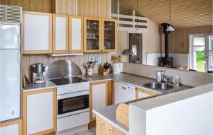 una cucina con elettrodomestici bianchi e armadietti in legno di Holiday Home Grævlingestien Sæby a Nordost Altre 5 foto