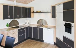uma cozinha com armários pretos e electrodomésticos brancos em Stunning Home In Vestervig With Wifi em Vestervig