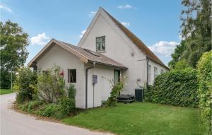 a small white house with a green yard at Awesome Home In Sams With Wifi in Nordby