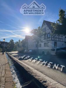 un cartello che dice appartamento una camminata accanto a un edificio di Studio am Waldbach a Gernsbach
