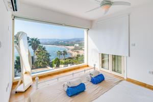 Zimmer mit einem großen Fenster und Meerblick in der Unterkunft Beach Front Villa Mer Blu by Ezoria Villas in Coral Bay