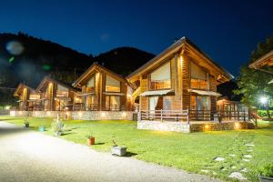 a large wooden house with a green yard at night at Natura Chalets in Megalo Chorio