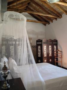 La Cañota Suite King Rooms Adults Only في Talara: غرفة نوم بسرير عليها حجاب