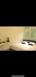 a bedroom with a bed and a desk and a window at se: 13A rue des Touleuses Pourpre in Cergy