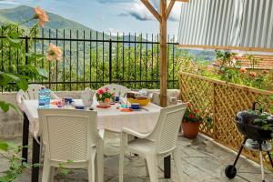 einen Tisch und Stühle auf einem Balkon mit Aussicht in der Unterkunft casetta della fontana in Serra Rocco