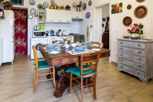 - une cuisine avec une table en bois, des chaises et une cuisinière dans l'établissement casetta della fontana, à Serra Riccò