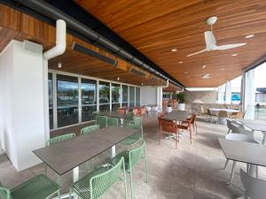 a restaurant with tables and chairs and windows at Pelican Waters Resort One Bedroom Apartment in Pelican Waters
