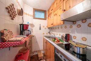 a small kitchen with wooden cabinets and a sink at Arianna - Happy Rentals in Livigno