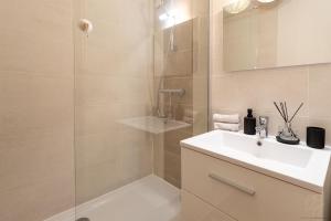 een badkamer met een douche, een wastafel en een spiegel bij Le République-Gare-Centre ville in Bourgoin