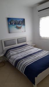 Cama en habitación blanca con una foto en la pared en Short Term Apartment Tel Aviv Bat Yam 352, en Bat Yam