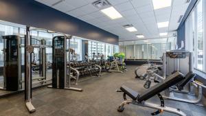 um ginásio com passadeiras e equipamento cardiovascular num edifício em Bold CozySuites with pool, gym, roof #8 em Dallas